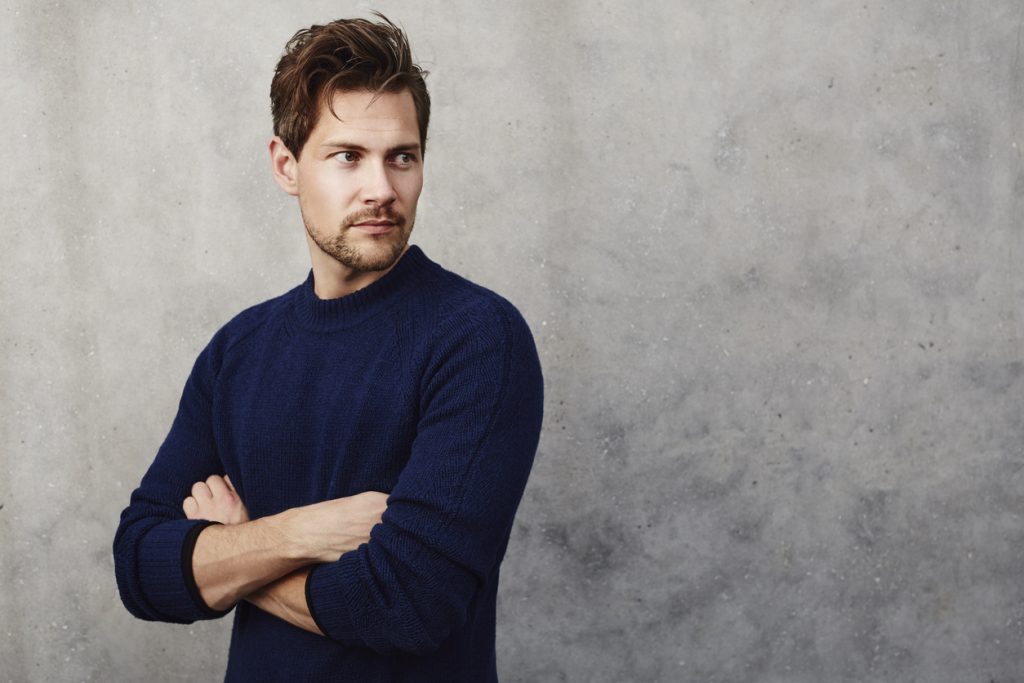 man short brown hair messy shag haircut navy sweater gray stone background shag haircuts for men and women toppik hair blog