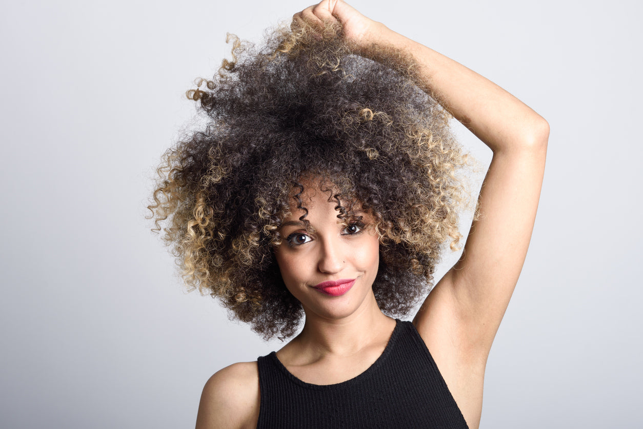 Woman smiling with an afro hairstyle