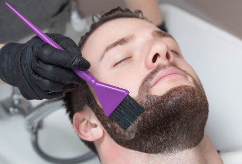 man having premature gray hair treatment of hair dye applied to his beard Toppik blog