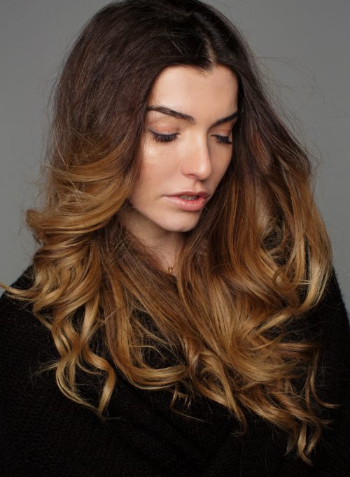 woman long wavy hair sombre hair color highlights looking down - What is sombre hair?