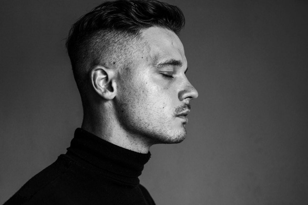 Black and white picture of a man with an undercut hairstyle