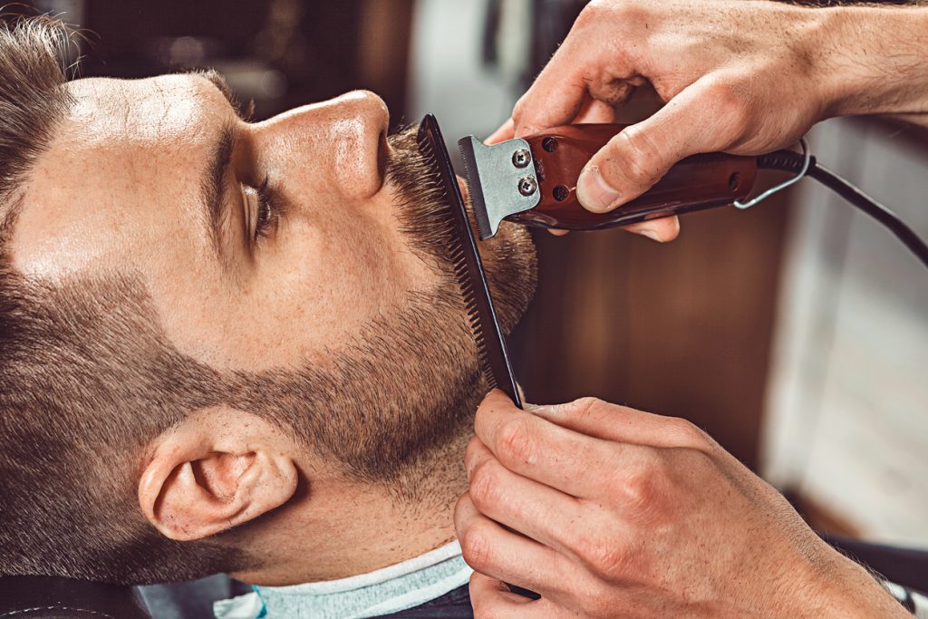 barber trimming beard perfecting beard care routine toppik hair blog