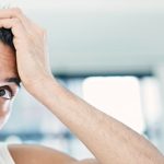 man brown hair examining scalp hair part mirror dealing with scalp folliculitis toppik hair blog master slider image