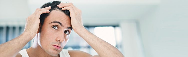man brown hair examining scalp hair part mirror dealing with scalp folliculitis toppik hair blog master slider image