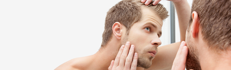 man examine thin hair hairline bald spot in mirror knowing your bald spot treatment options toppik hair blog
