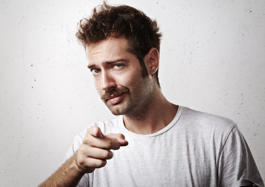 A young man proudly wears his chevron mustache - a full, retro mustache style that reaches the upper lip.
