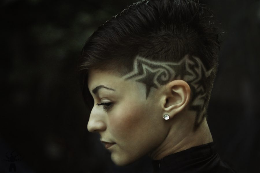 woman shows off her Shaved Hair Stars in her short dark hair 