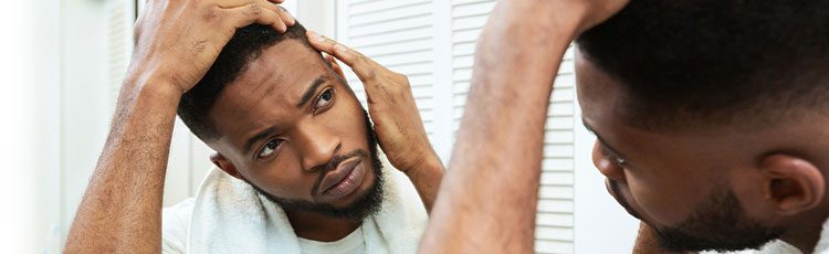 man examining hairline in mirror beard african american can stress cause hair loss toppik hair blog